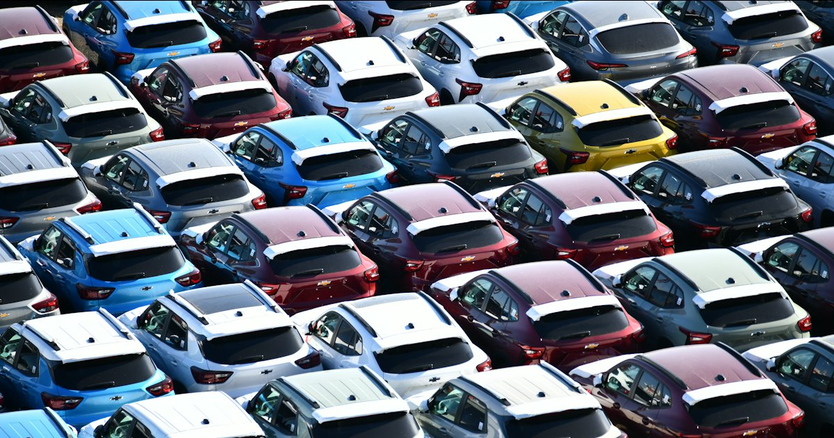 Rijen auto's in allerlei kleuren op een groot terrein, van bovenaf gezien