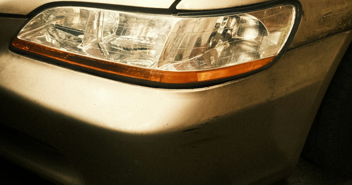 Koplamp en bumper van een gebruikte auto met kleine krassen